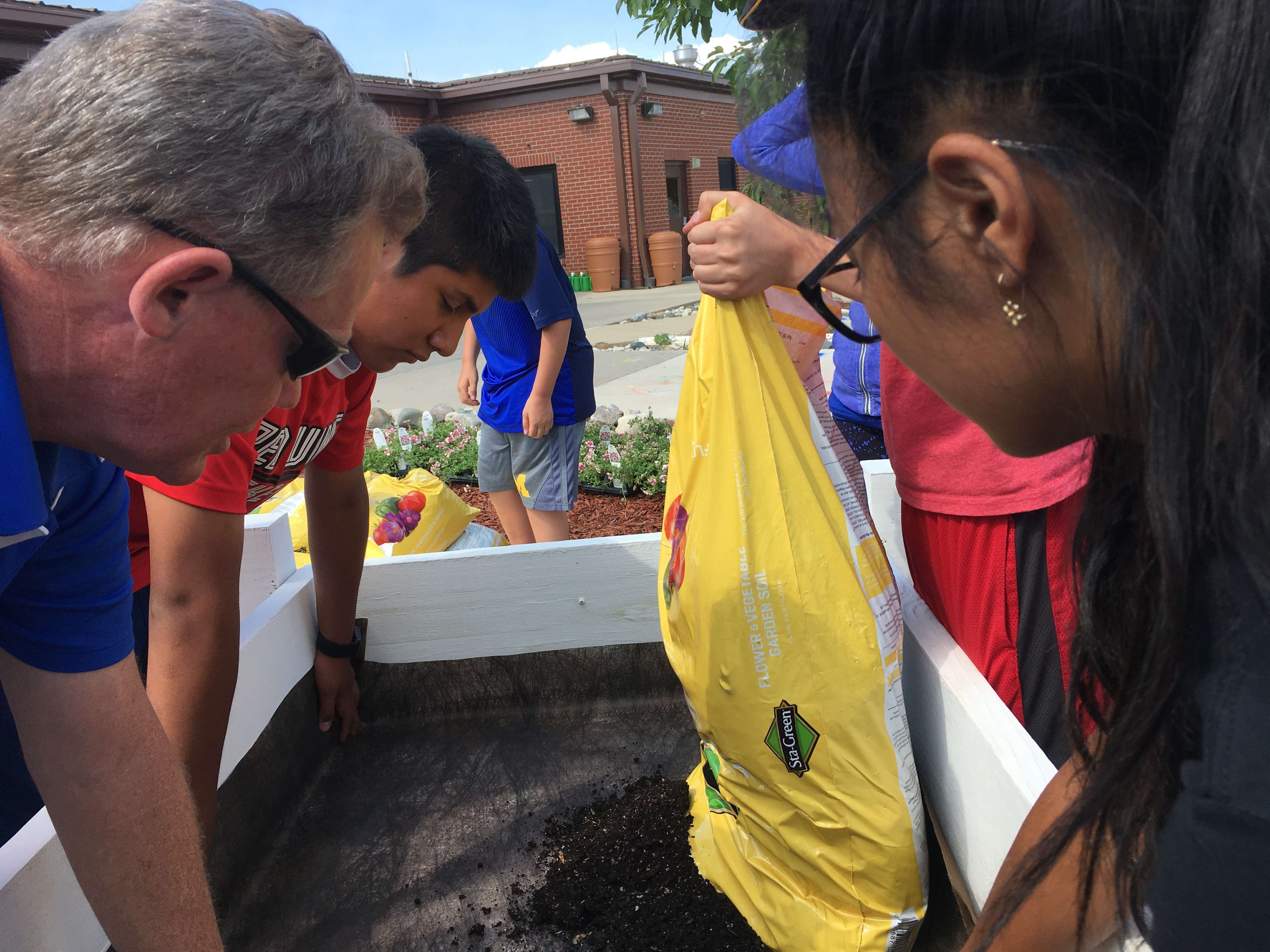 DTA 4-H Club Members add soil to flower bed